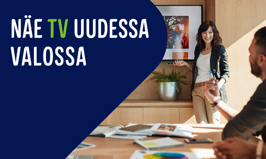 Nainen esittelee sisältöä kokoushuoneessa olevasta TV:stä, sekä teksti "Näe TV uudessa valossa"